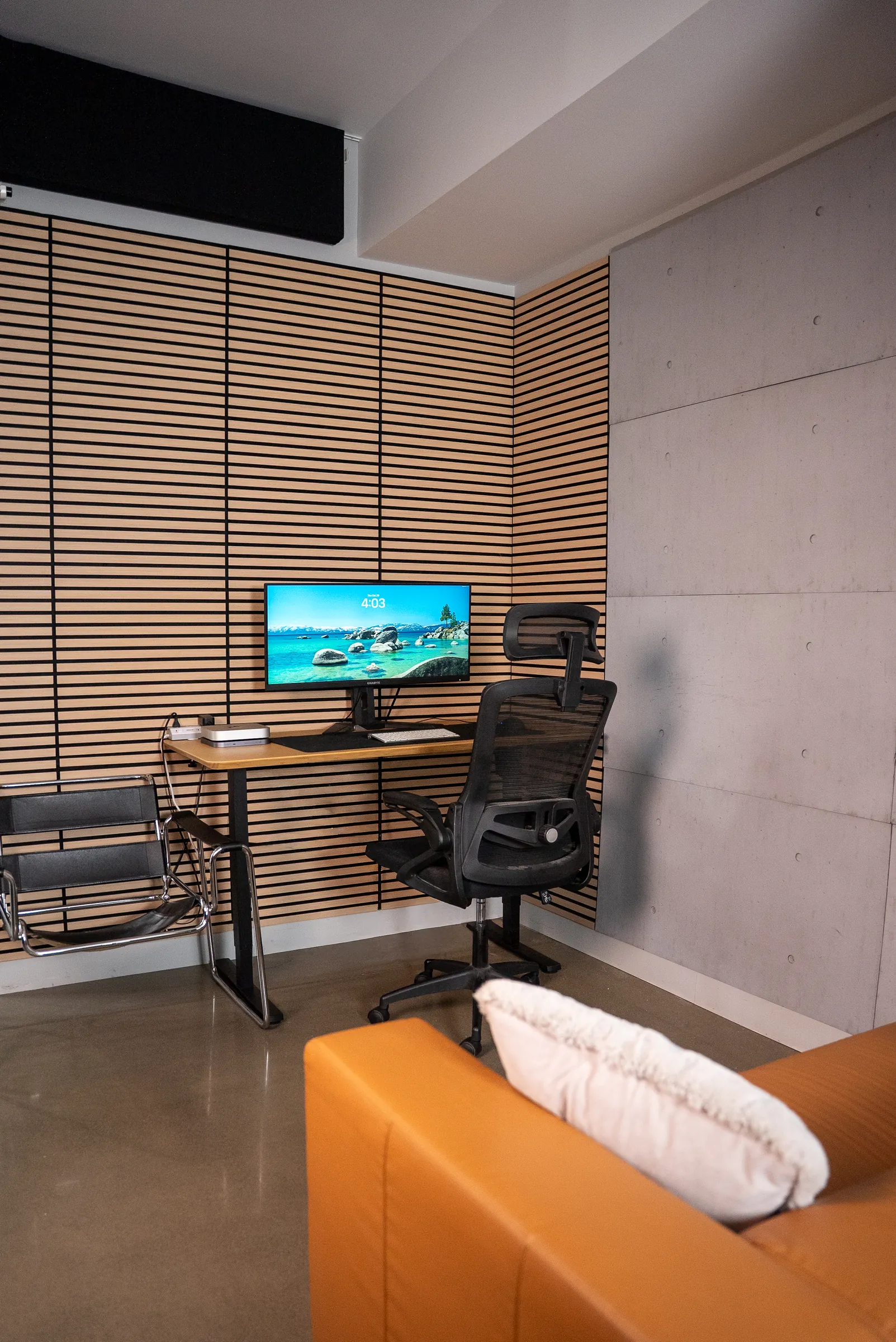 Le bureau fermé du Stoud, avec son poste devant les lattes de bois et un divan en cuir
