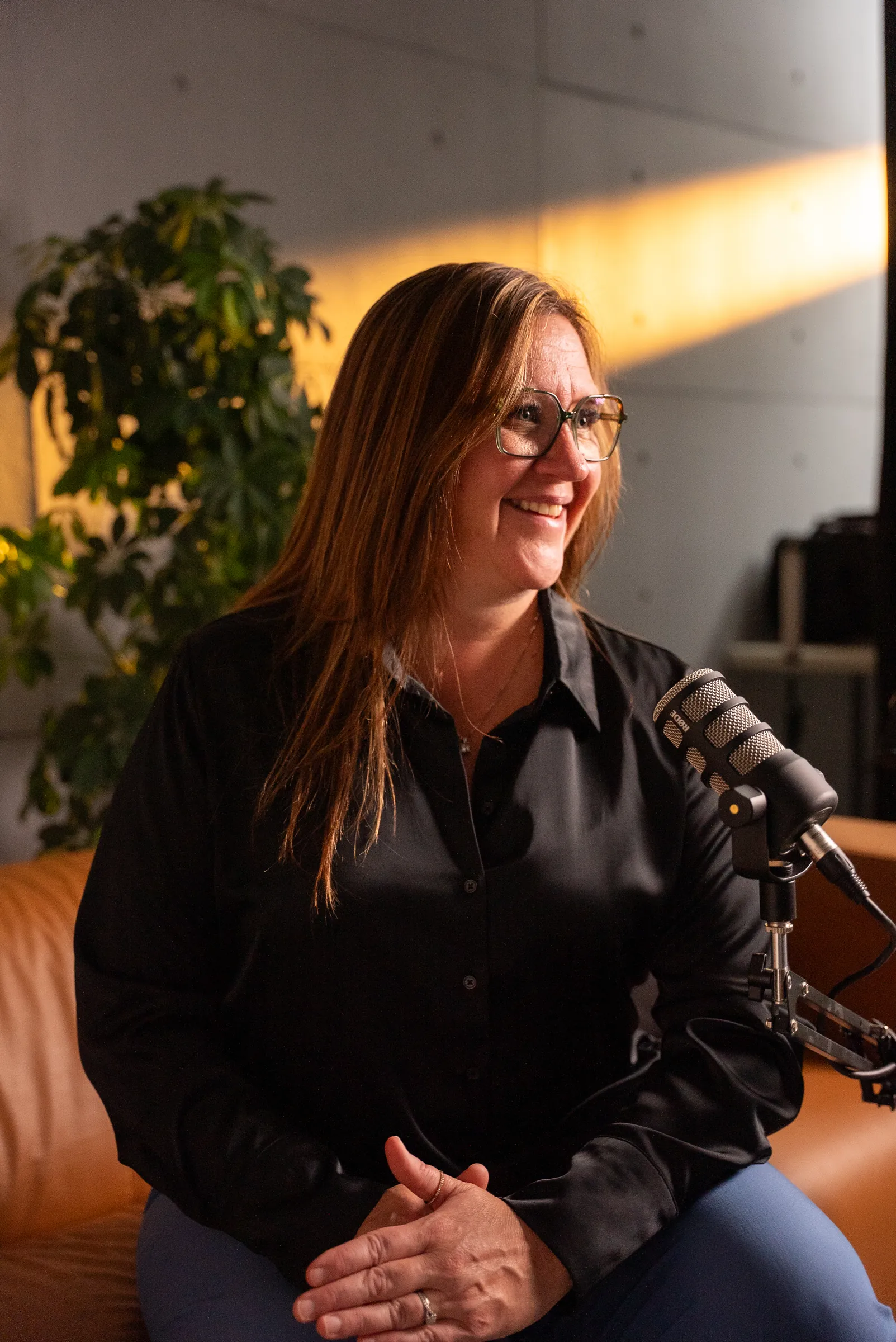 Une invitée sourit au micro dans le studio podcast du Stoud
