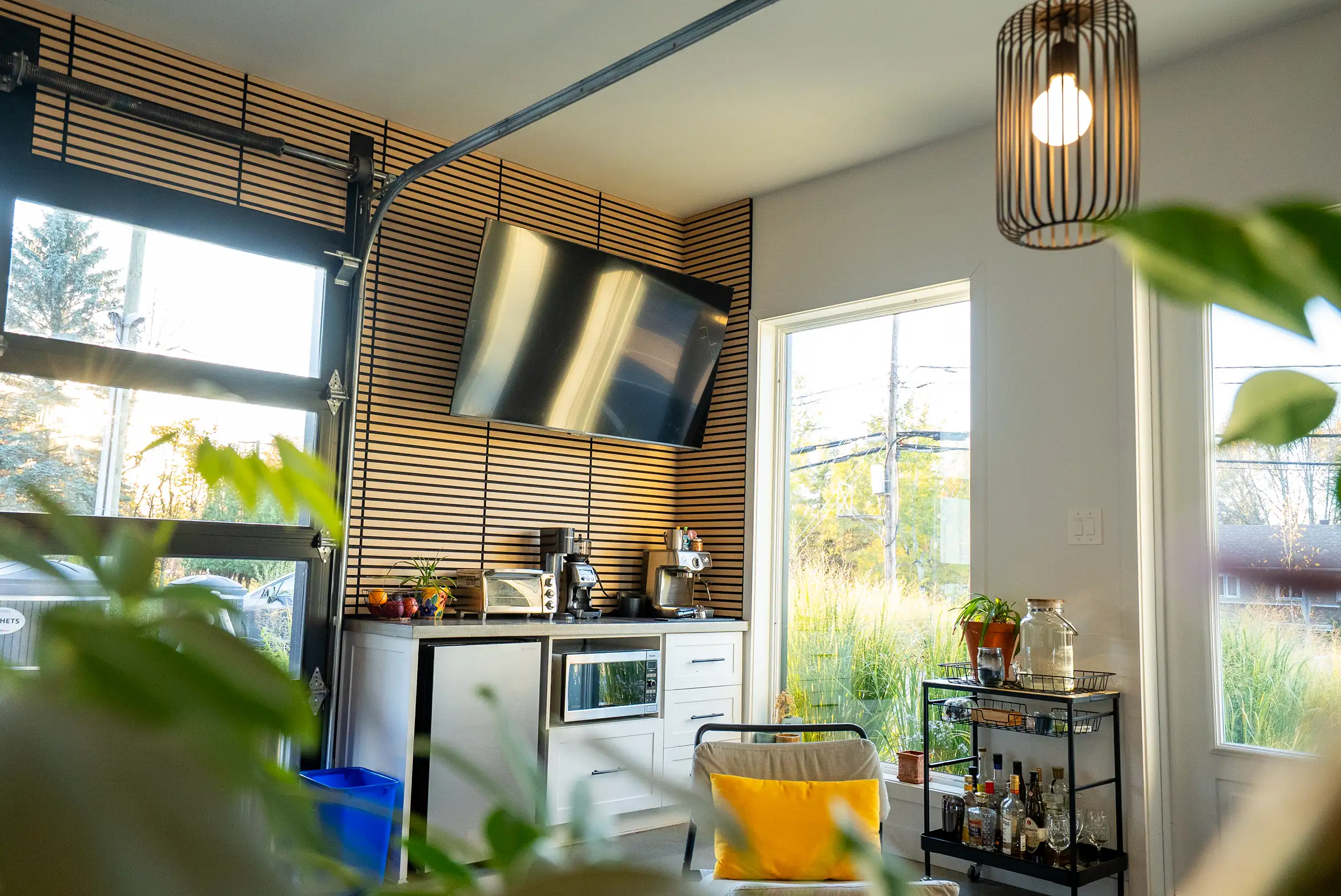 Le coin café derrière une plante, avec la porte de garage