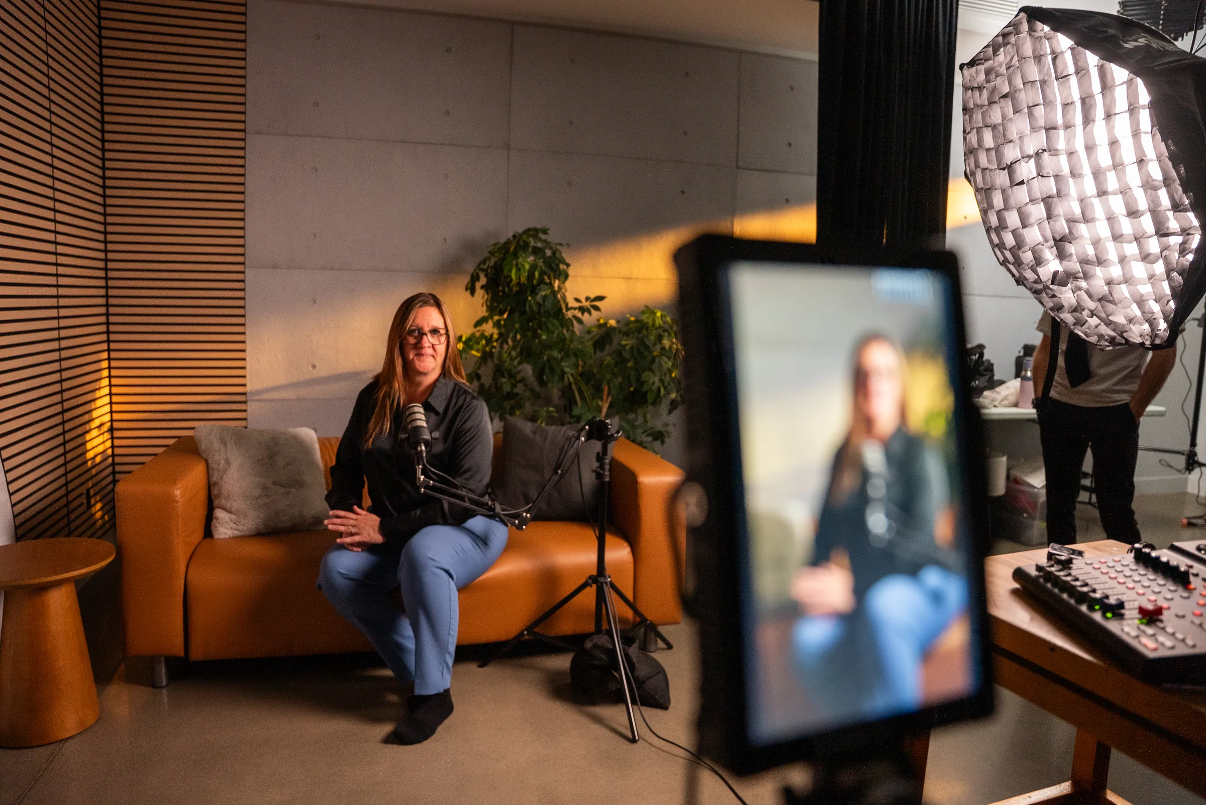 Le plateau du studio podcast vu depuis la régie : le divan, l'invitée, la caméra et les lumières