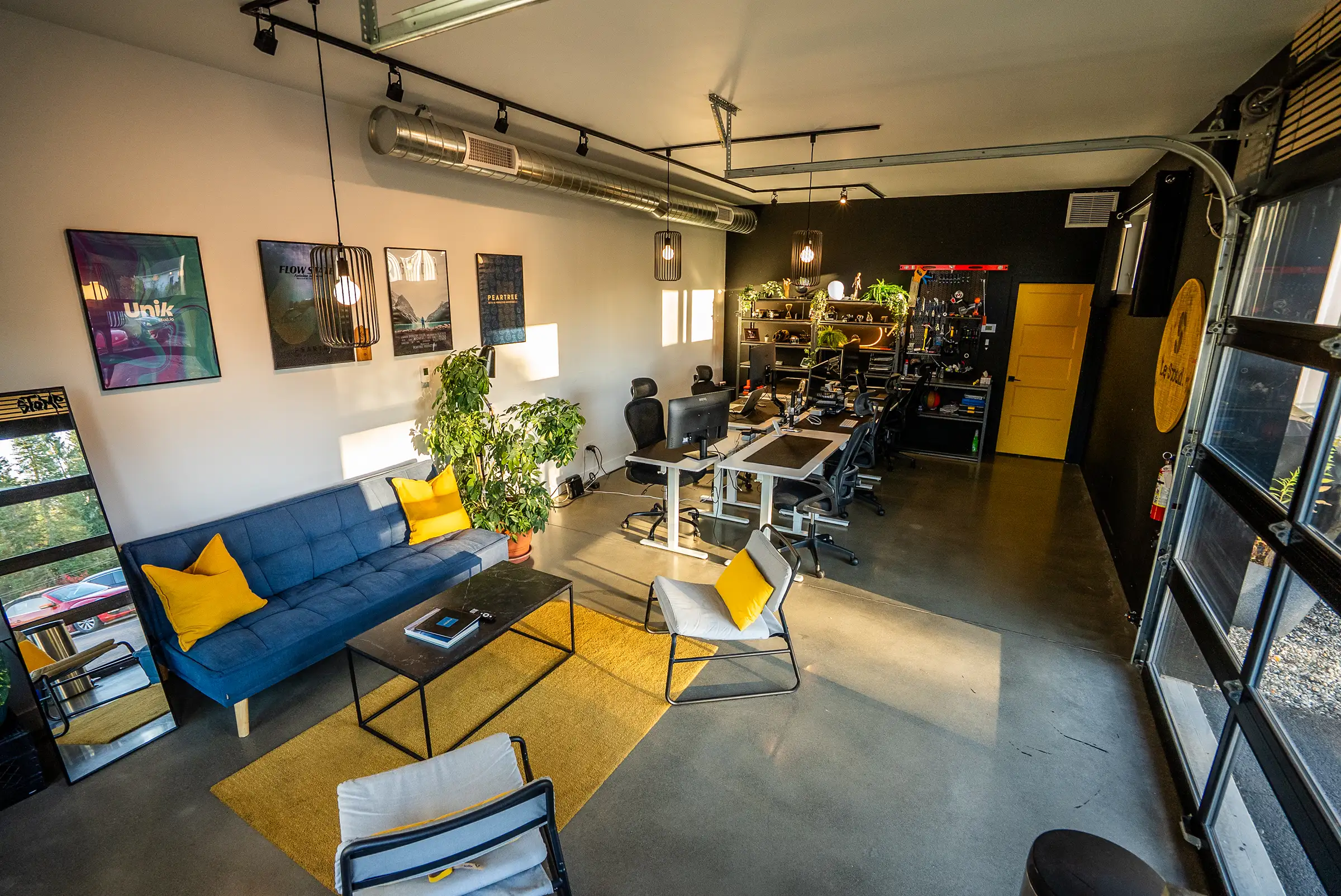 L’espace ouvert du Stoud : le salon, les postes, l’étagère et la porte de garage