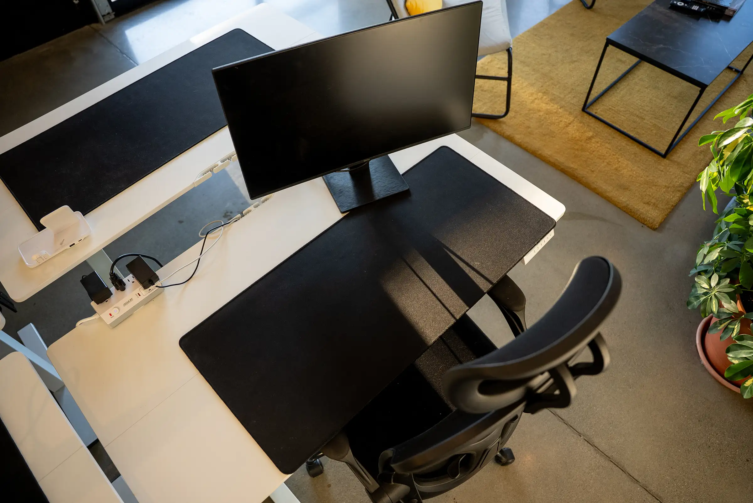 Un poste de travail libre vu d’en haut, avec son écran et sa chaise