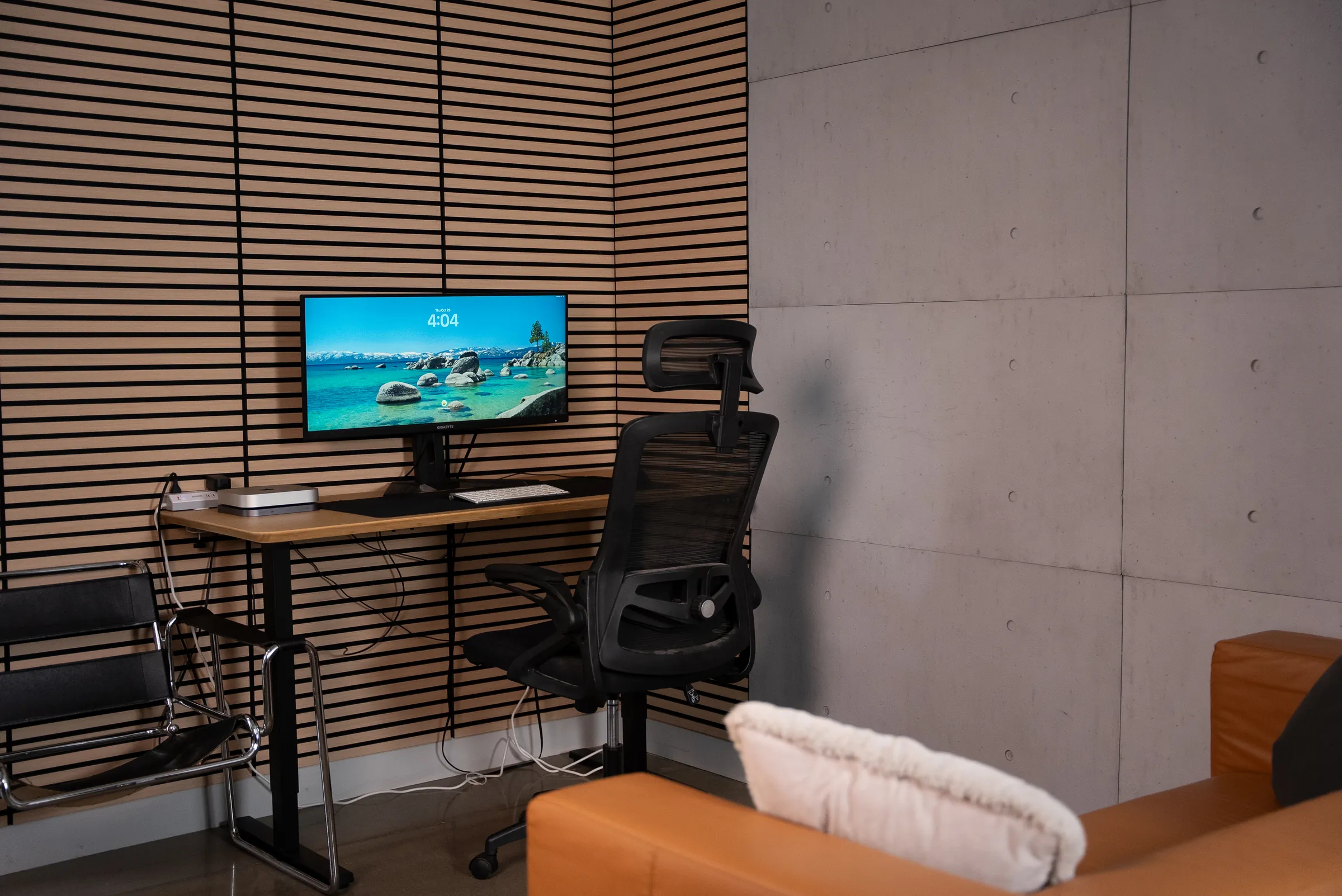 Le bureau fermé du Stoud : un poste devant le mur de lattes de bois, une chaise ergonomique et le divan