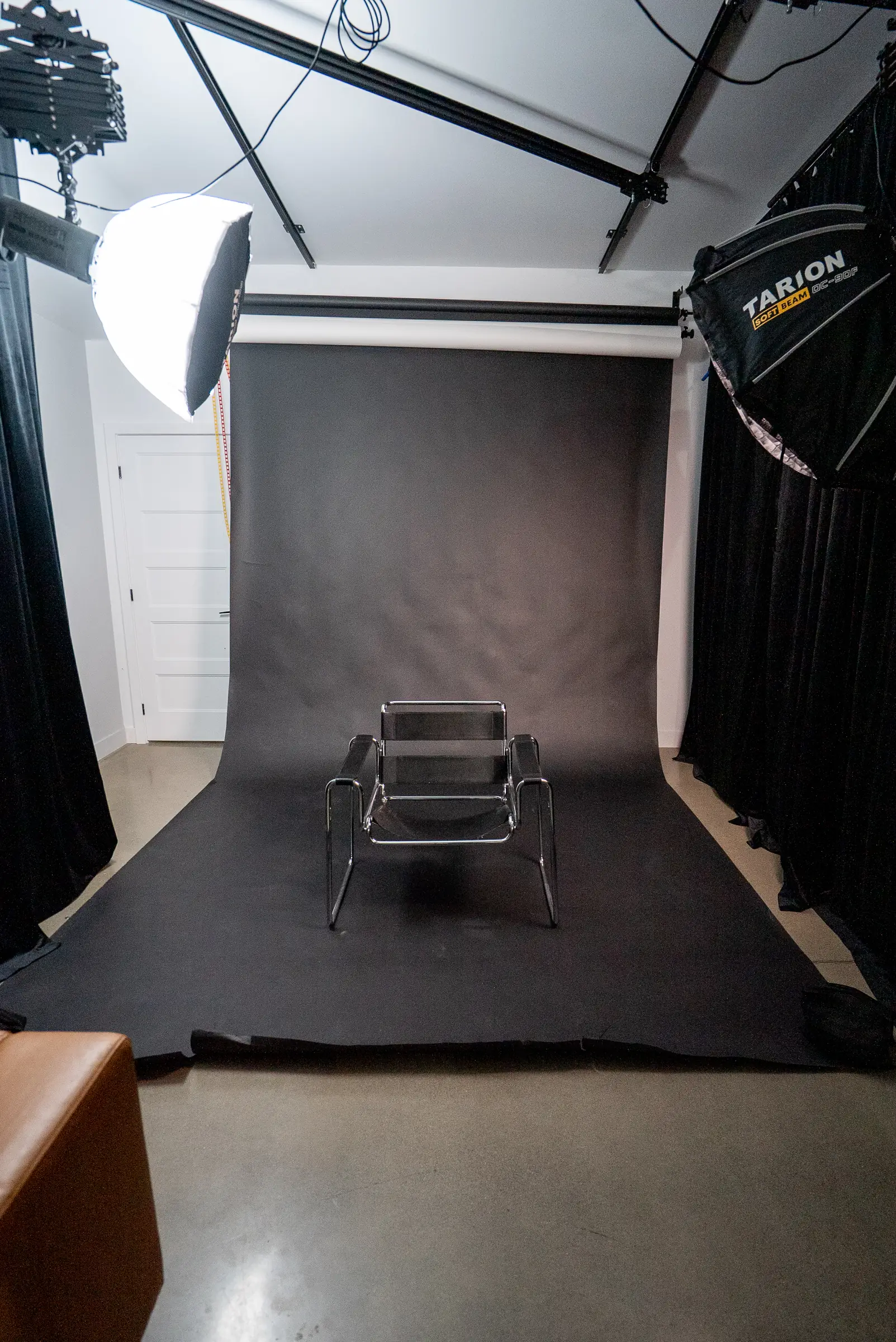 Le studio photo du Stoud monté en fond noir, avec une chaise et des boîtes à lumière