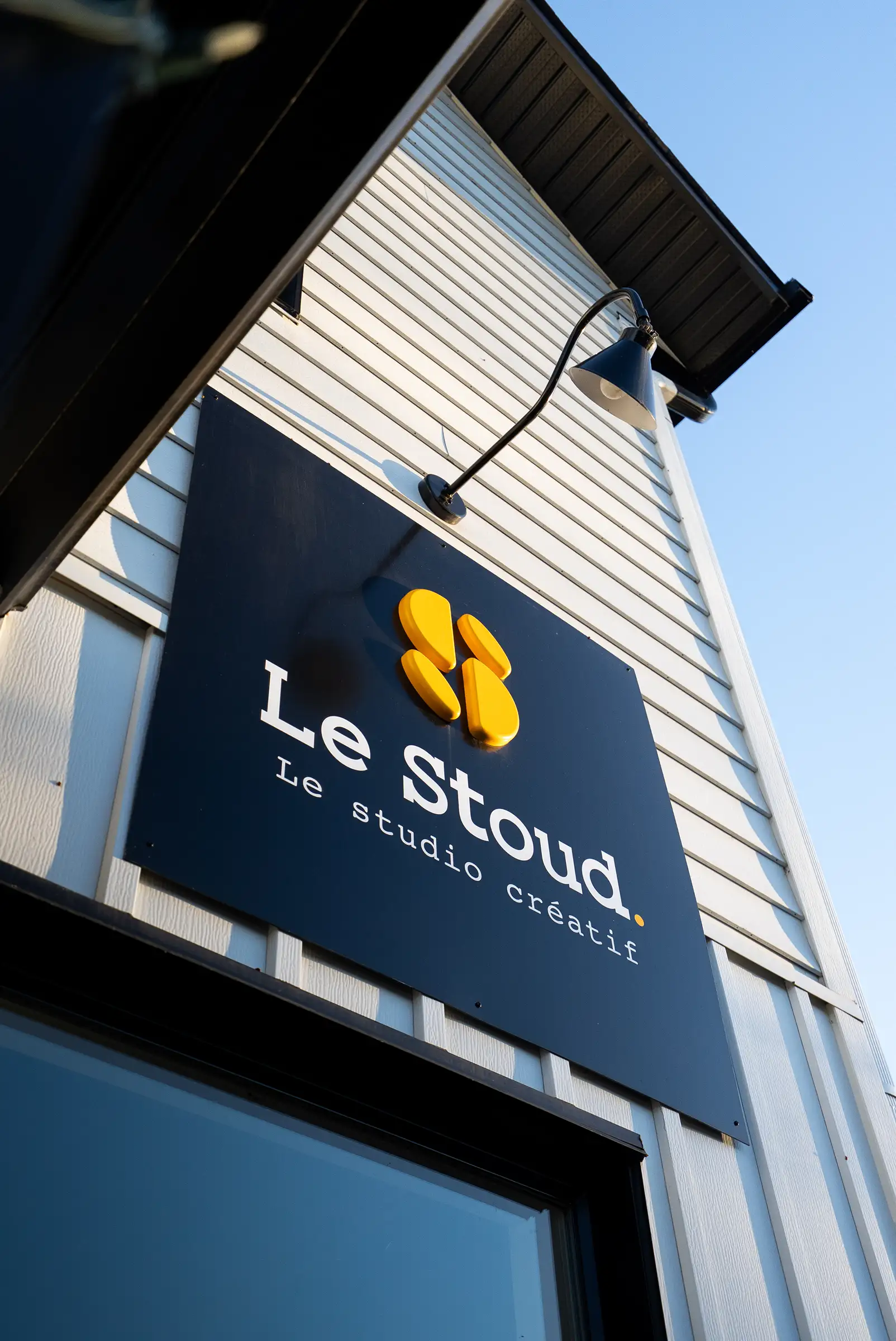 L’enseigne du Stoud en gros plan, sur un ciel bleu