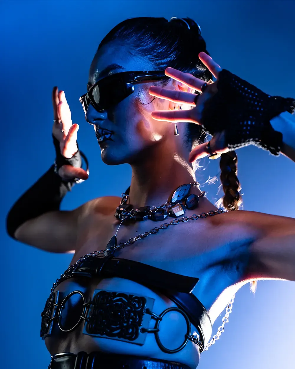 Séance créative au Stoud : mannequin en bijoux métalliques et lunettes noires, sur fond bleu