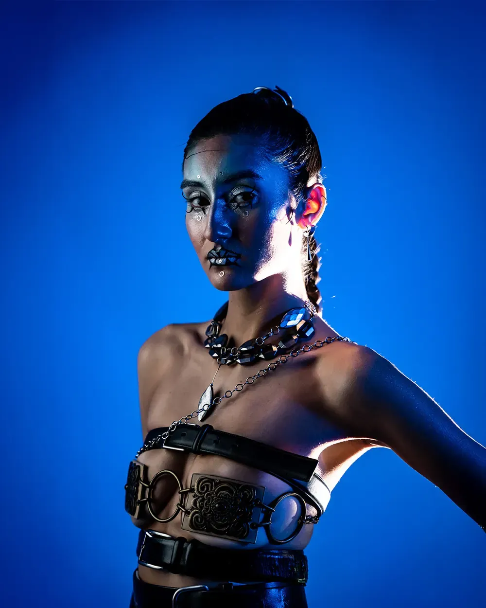 Portrait d'une mannequin aux bijoux argentés, éclairée en bleu